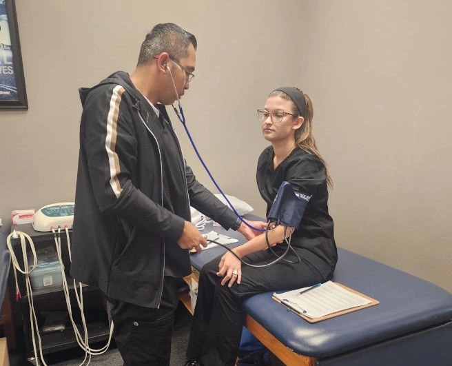 student taking another student's blood pressure